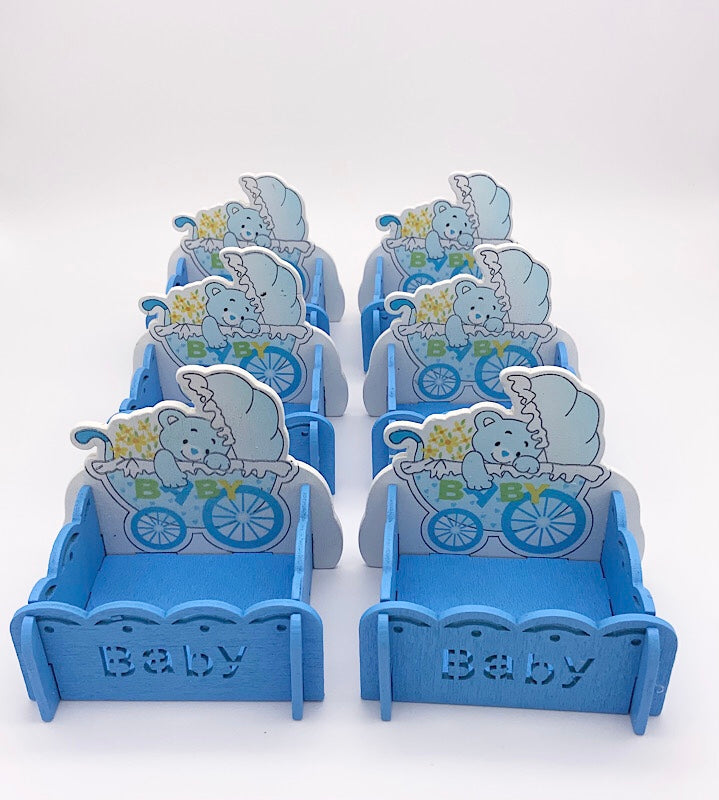 Set of blue baby shower treat boxes with baby-themed decorations.